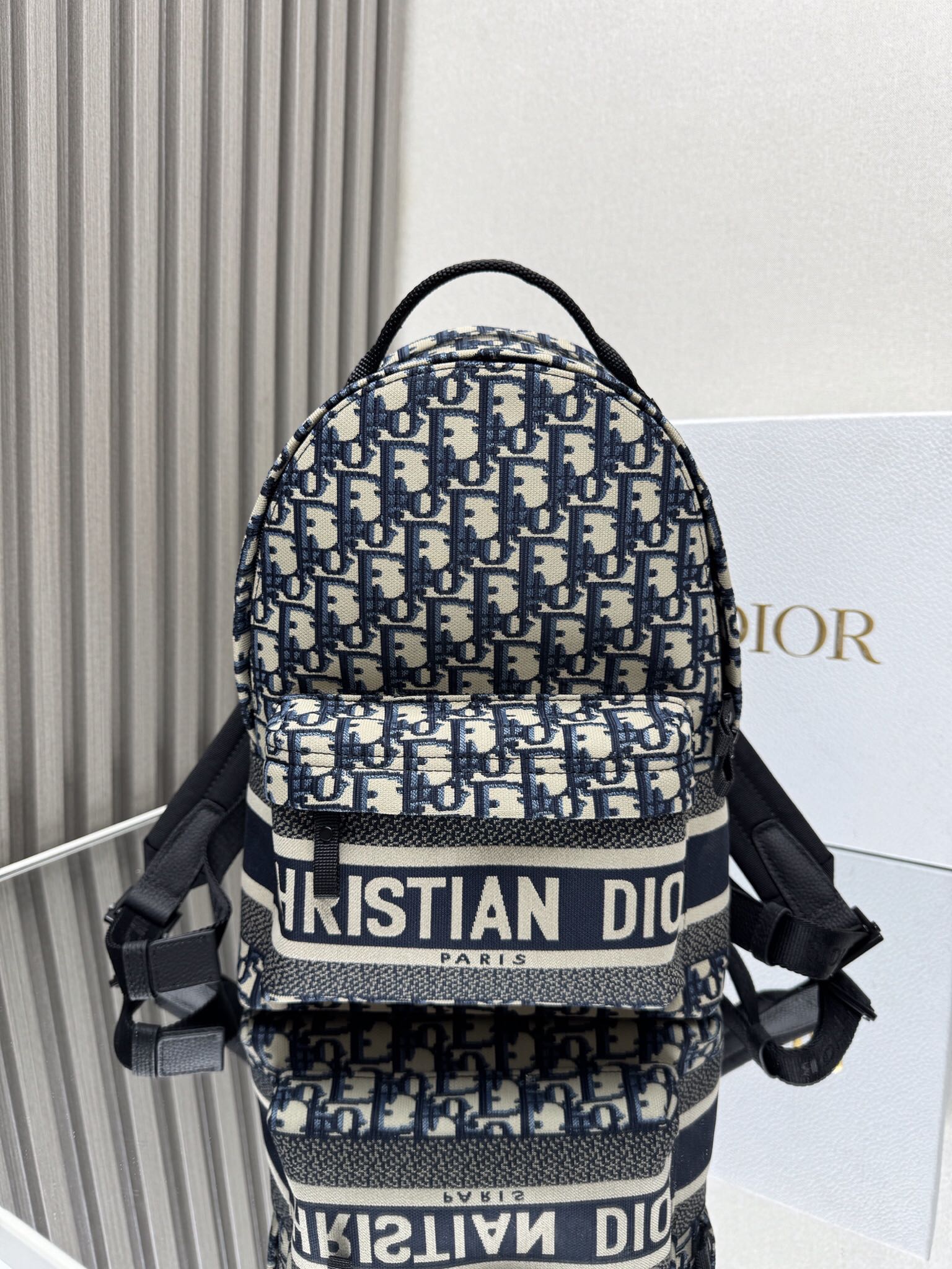 Dior Travel Backpack "Blue Cloth Small" This Travel backpack combines classic details with a stylish and practical design. Crafted from blue jacquard technical fabric, it features an all-over Oblique print and a striking Christian Paris signature on the front Dimensions: 23.5 x 32 x 11 cm (L x H x W)
