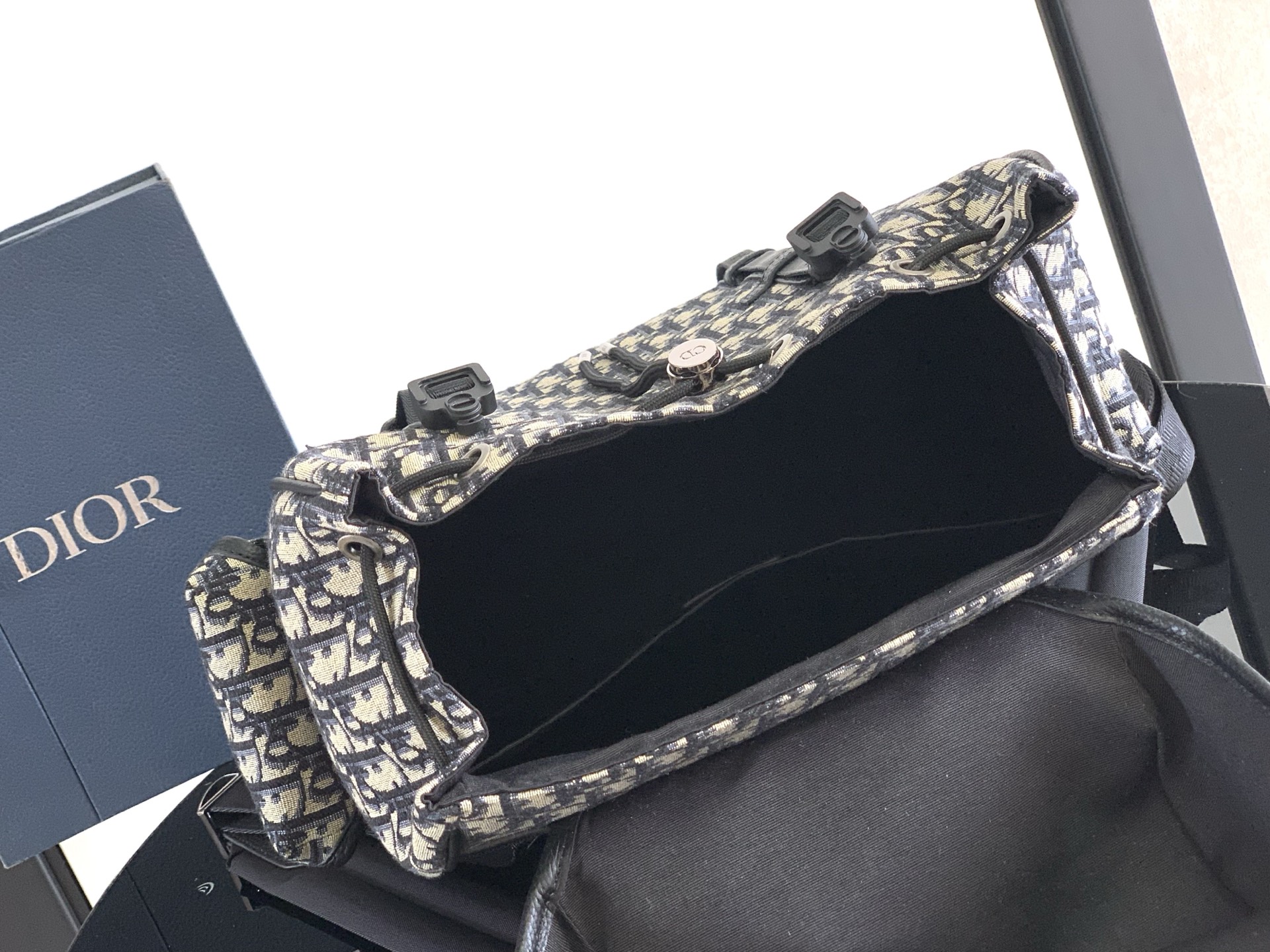 Dior Hit The Road Flap Backpack seamlessly blends modern style Crafted from beige Oblique printed fabric Size: 43 × 43 × 18 cm (L × H × W) Lining: Fabric (excluding trims and decorative stitching) Main compartment: Flap closure with drawstringModel number: FK-1ESBA205YKY_H03E 9 Dior Hit The Road Flap Backpack seamlessly blends modern style Crafted from beige Oblique printed fabric Size: 43 × 43 × 18 cm (L × H × W) Lining: Fabric (excluding trims and decorative stitching) Main compartment: Flap closure with drawstringModel number: FK-1ESBA205YKY_H03E - Image 9